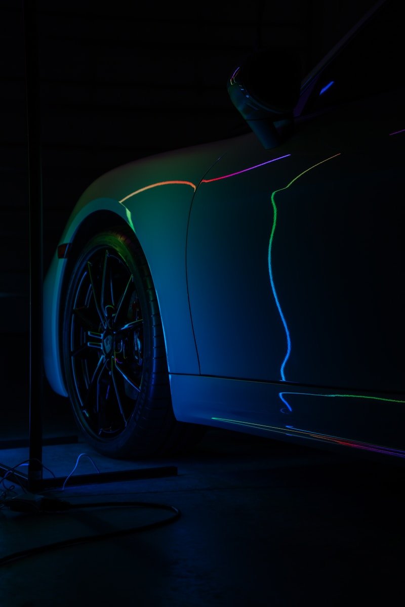 A car parked in a dark garage with neon lights